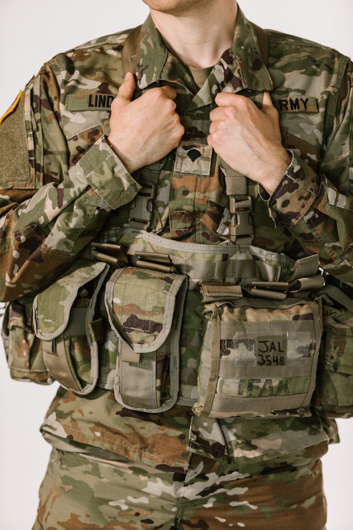 Home Close-up of soldier in camouflage with tactical gear on white background.